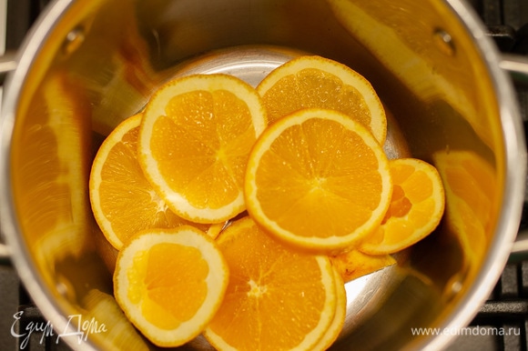 Половину лимона и целиковый апельсин нарезать кружочками и бросить в кастрюлю.