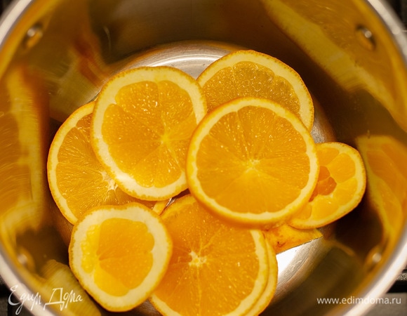 Половину лимона и целиковый апельсин нарезать кружочками и бросить в кастрюлю.