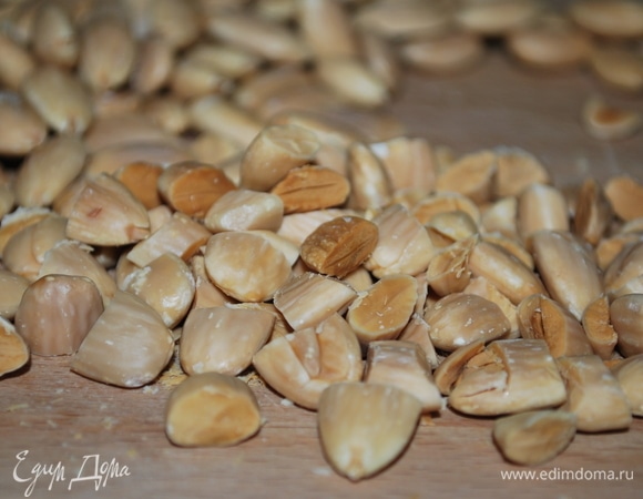 Миндаль вымойте, опустите в кипяток, подержите пару минут и очистите от кожуры. Обжарьте на сковороде или в духовке, дайте ему остыть и крупно порубите.