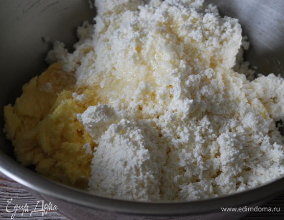 Добавьте протертый творог и мед, перемешайте ложкой до объединения.