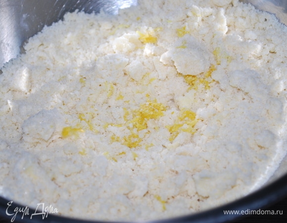 Сделайте штрейзель для кекса: масло нарежьте кусочками, добавьте муку с сахаром и цедру лимона, разотрите руками до образования крошки.