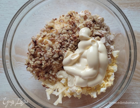 В чаше смешать куриное филе, яйца, сыр, добавить рубленые орехи, заправить майонезом и перемешать.