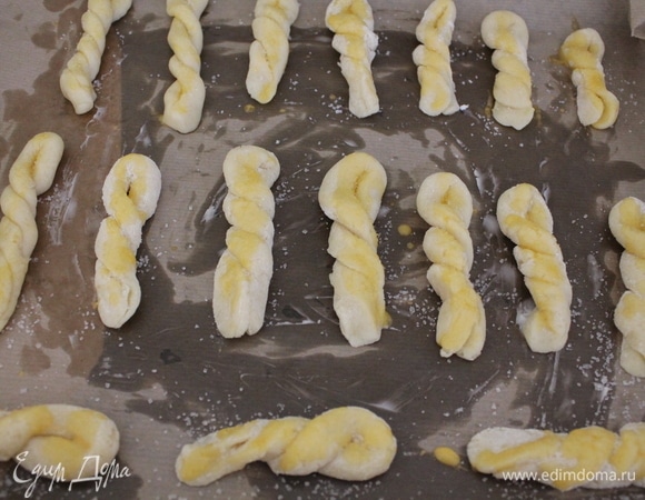 Противень застилаем бумагой для выпечки. Я использовала коричневую бумагу, смазав ее немного сливочным маслом. Выкладываем заготовки, покрывая их молочно-яичной массой, посыпая сахаром. Ставим в духовку, разогретую до 180°C, примерно на 13–15 минут.