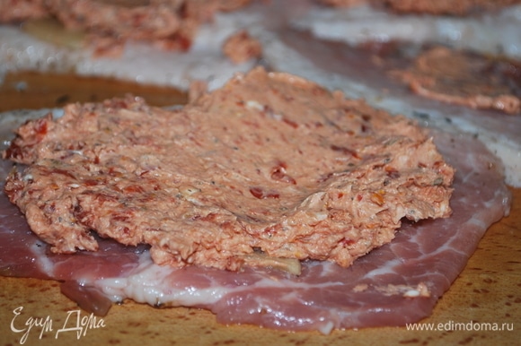 Смажьте мясо маслом от вяленых томатов, на один край выложите сырную начинку.