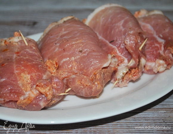 Сверните мясо рулетиком и скрепите деревянной шпажкой.