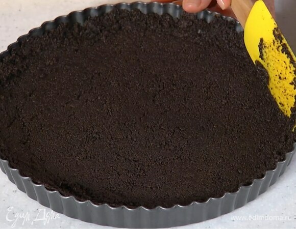 Печенье измельчить в блендере в очень мелкую крошку, влить растопленное масло и перемешать, затем выложить все в форму для выпечки и плотно утрамбовать, так чтобы получился корж с бортиками.