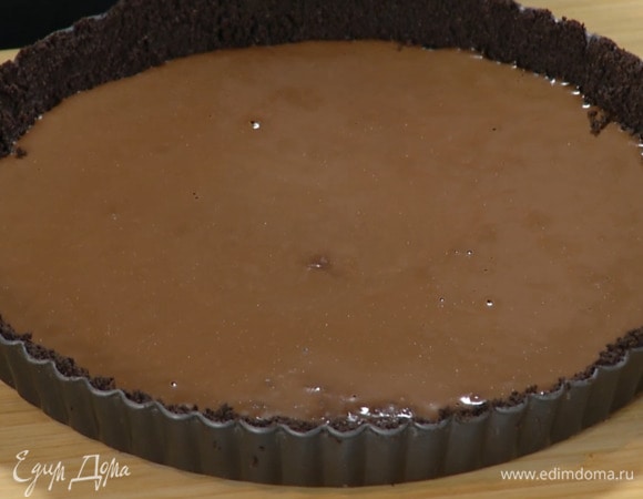 В небольшую кастрюлю влить 200 мл сливок, добавить 100 г поломанного на кусочки шоколада, все растопить, вылить на корж и равномерно распределить, затем отправить на час в холодильник.