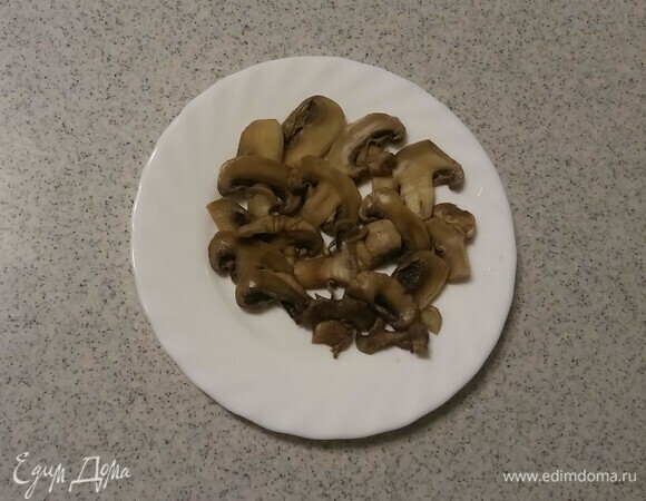 Охлажденные отварные шампиньоны нарезать тонкими пластинами.