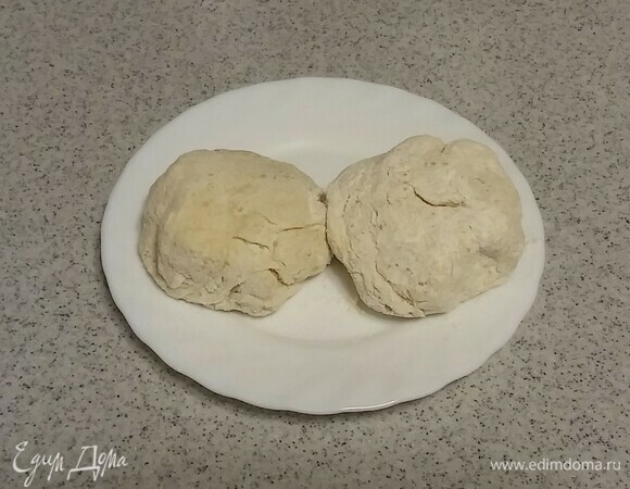 Сначала нужно приготовить тесто. Для этого в глубокой емкости нужно смешать просеянную блинную муку, кефир, соль и сахар. Вымесить тесто в шар, который не липнет к рукам. Затем разделить его пополам.