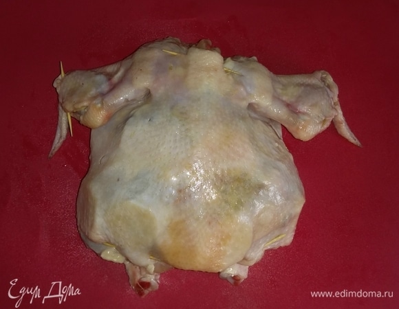 Затем под куриную кожу положить кружки картошки, оливок и чеснока (со всех сторон тушки).