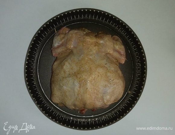 Смазываем противень растительным маслом и выкладываем на него куриную тушку. Разогреваем духовку до 200°C и ставим противень с курицей на 20 минут, а затем уменьшаем температуру до 185°C и продолжаем запекать курицу еще 50 минут (время приготовления зависит от вашей духовки).