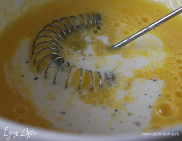 Отделите желтки от белков. В глубокой миске венчиком перемешайте до объединения желтки со второй половиной сахара. Добавьте остывшие сливки с семенами ванили, перемешайте.