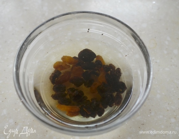 Изюм промойте, залейте кипятком, оставьте минут на 10 и затем воду слейте.