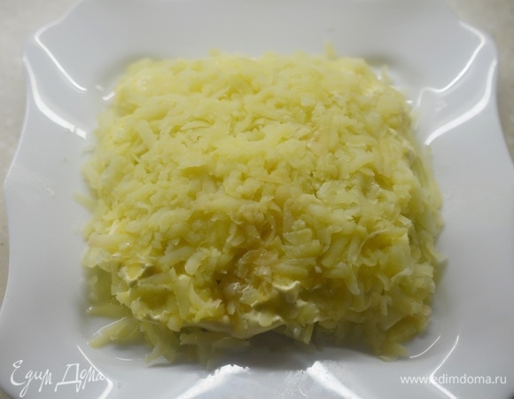 Картофель почистите, натрите на терке и выложите следующим слоем. Немного майонеза.