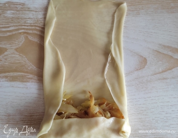 На один край теста выкладываем 1 ст. л. начинки, подгибаем боковые края и сворачиваем рулетик.