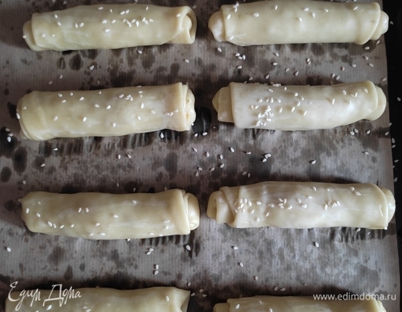 Выкладываем на противень, застеленный пергаментом. Можно смазать немного водой и посыпать кунжутом. Если вы не соблюдаете пост, то можно смазать желтком, тогда пирожки будут более румяные, а кунжут не будет осыпаться.