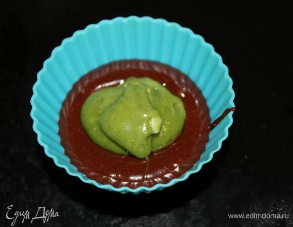 Когда ганаш застынет, можно приступать к выпеканию. Заполните формочки тестом примерно на половину. Положите в центр чайную ложку ганаша, затем заполните формочку тестом до верха.