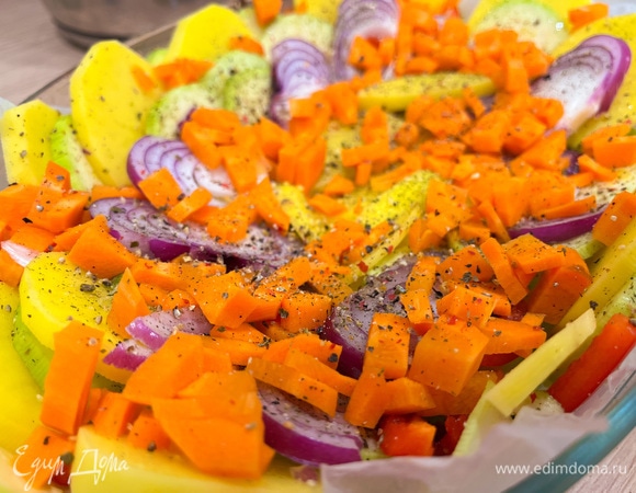 Почистите морковь и нарежьте мелким кубиком. Выложите морковь сверху по всей форме. Посолите, поперчите и добавьте сухого чеснока. Отправьте на 10 минут в предварительно разогретую до 180°C духовку.