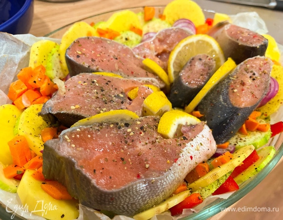 Вытащите форму из духовку и выложите поверх овощей рыбу. Посолите, поперчите и приправьте сушеным чесноком. Сбрызните лимоном (между рыбными стейками вы можете положить дольки лимона). Отправьте в духовку еще на 30 минут.