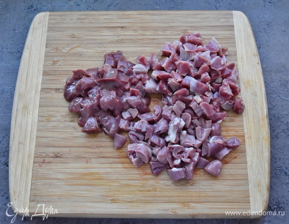 Подготовить потрошки, освободив их от всего лишнего (от жира, протоков, сосудов, сгустков крови). Хорошо промыть и нарезать небольшими кусочками. Такими же кубиками нарезать половину филе грудки.