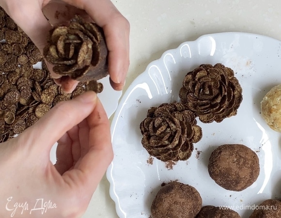 Шоколадными хлопьями дополнить образ шишки. Начинать сверху, постепенно спускаясь вниз.