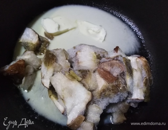 Сливочное масло разогреть на сковороде вместе с растительным. Выложить замороженные грибы. Накрыть крышкой и на сильном огне довести до разморозки.