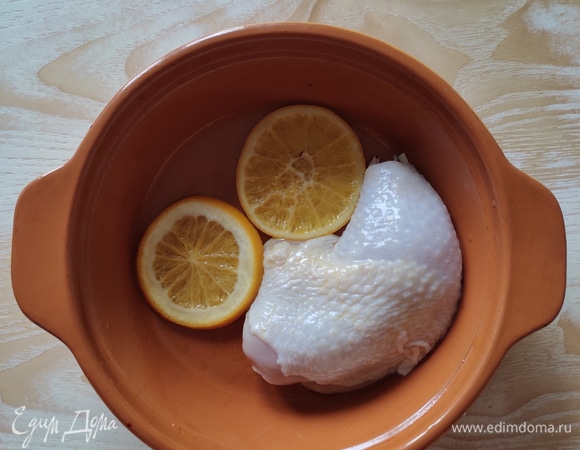 На дно формы для запекания выложить кусочки апельсина, который был в маринаде, сверху уложить куриные бедра.