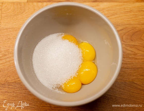 В другой чаше соединить желтки с сахаром. Взбить миксером до посветлевшей массы.