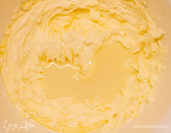 Постепенно вливать сгущенное молоко, не переставая взбивать масло.