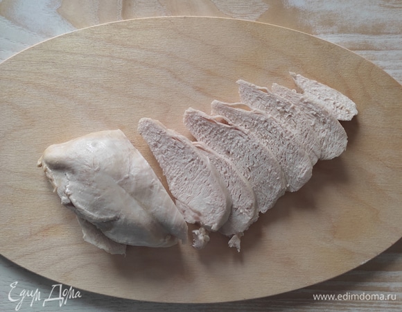 Куриное филе отварить, остудить и нарезать тонкими ломтиками.