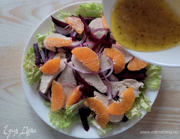 Далее — лук, куриное филе и нарезанный клементин (можно заменить апельсином). Полить салат заправкой.