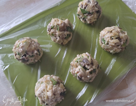 Смочить руки водой и из массы слепить шарики примерно по 50 г, у меня из указанной граммовки получилось 8 шт. Шарики выложить на доску, застеленную пищевой пленкой, и поставить в морозилку на 30 минут. Немного подмороженные шарики при панировке не рассыпаются и хорошо держат форму.