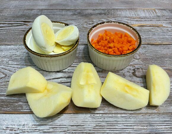 Яйца предварительно отварите и остудите, очистите от скорлупы. Морковь отварите, очистите и нарежьте на мелкие кубики. Яблоко очистите от семян и кожуры.