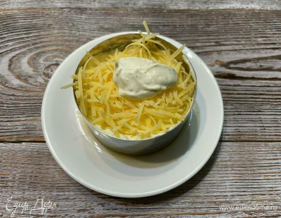 Соберите салат в кулинарном кольце. Первый слой — яблоко, натертое на крупной терке, второй — мелко нарезанные яйца, третий — сыр, четвертый — морковь, между слоями — приготовленный соус. В конце выложите мясо индейки.