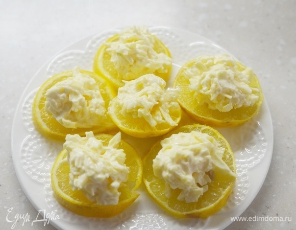 На кружки лимона выложите острый сыр.