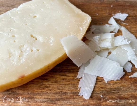 Сыр натрите слайсами с помощью овощерезки.