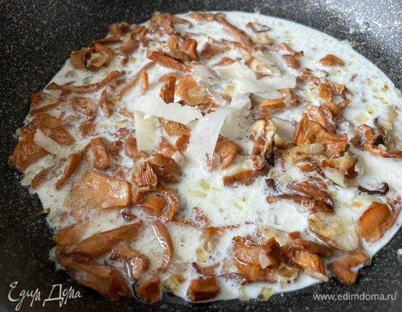 В сковороду к грибам и луку налейте сливки 10% и всыпьте половину натертого сыра, прогрейте все вместе в течение 30 секунд. Желательно, чтобы сливки не закипели.