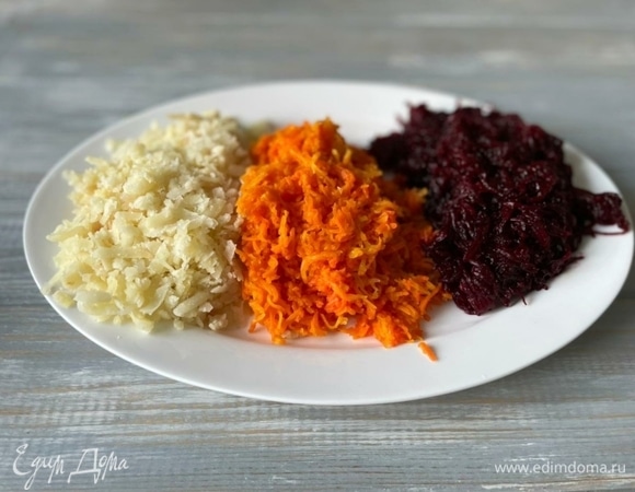 Морковь, картофель и свеклу вымойте и отварите до готовности. Картофель натрите на крупной терке, а морковь со свеклой натрите на мелкой терке.