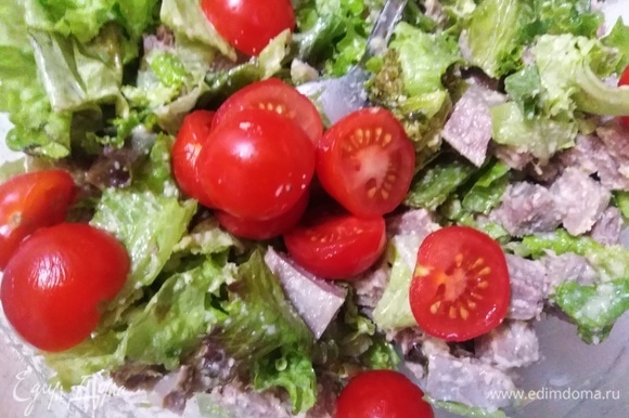 Нарезать томаты черри и соединить с салатом.