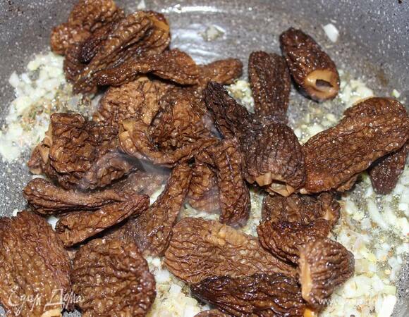 Отожмите сморчки, добавьте их к луку и прожарьте пару минут со всех сторон.