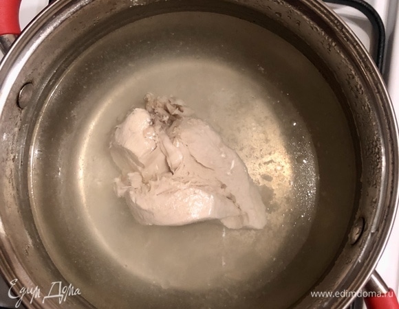 Отварить куриную грудку до готовности.