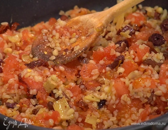 Добавить в сковороду готовый булгур и мякоть помидоров без жидкости, все перемешать и слегка обжарить, посолить, поперчить, еще раз перемешать и снять с огня.