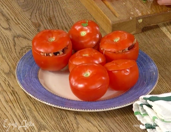 Плотно нафаршировать помидоры начинкой, накрыть крышечками и поместить в глубокую сковороду или форму для запекания.