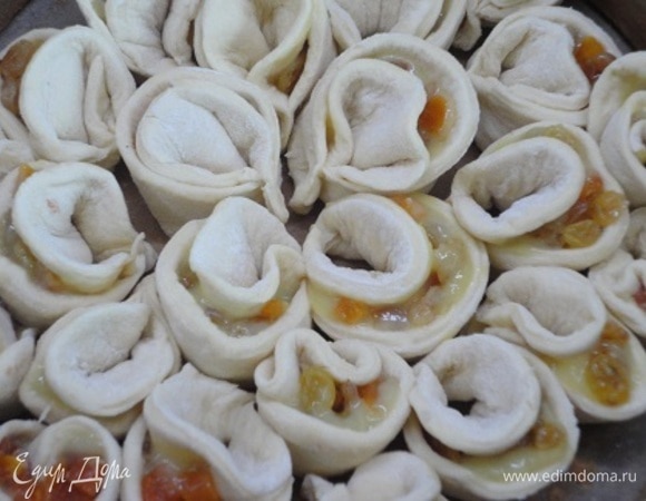 Выкладывайте получающиеся лепестки в форме цветка, начиная от центра формы для пирога. Кладите лепестки открытым краем вверх. Смажьте пирог сливками и оставьте для подъема на 20 минут.