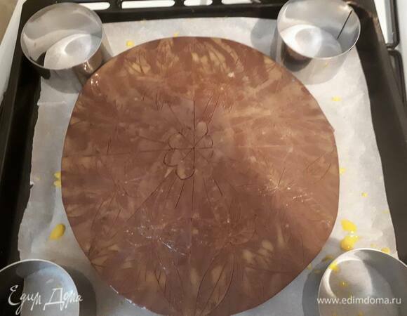 Когда галета застынет, выложите ее на противень, покрытый пекарской бумагой, той стороной, которая была сверху. Другая сторона теперь плоская, и на ней удобно рисовать. Взбейте яйцо с сахарной пудрой и молоком, слегка смажьте галету и острым ножом начертите рисунок. Надрезы должны быть легкими: если вы проткнете тесто, начинка может вытечь.