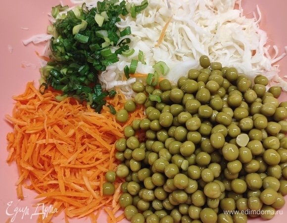 Капусту тонко нашинковать. Я это делала овощечисткой. Морковь натереть на терке для корейской моркови. Зеленый лук мелко нарезать, его добавляйте по вкусу. Всыпать зеленый горошек.