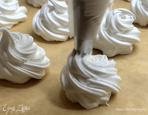 Когда масса белая, плотная и хорошо держит форму, перекладываем ее в кондитерский мешок. Противень застилаем пергаментной бумагой и отсаживаем меренгу (4–5 см в диаметре).