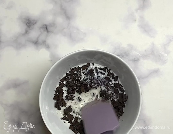 Готовим глазурь. Шоколад мелко рубим ножом, заливаем горячим молоком или сливками. Быстро перемешиваем, чтобы шоколад успел растопиться, но не свернуться. Постепенно добавляем молоко до нужной консистенции.