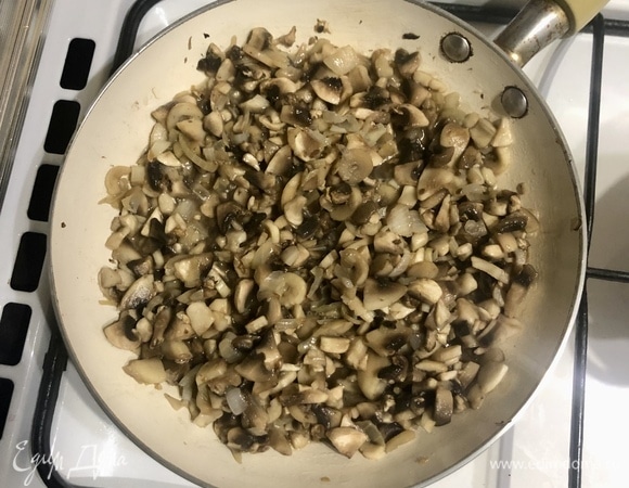 Разогреть сковороду с растительным маслом и обжарить лук до золотистости, добавить нарезанные шампиньоны, готовить до испарения жидкости, снять с огня.
