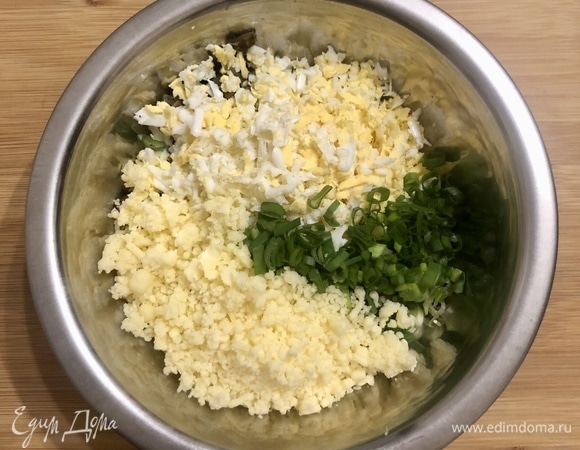 Сыр и яйца натереть на крупной терке. Зелень и чеснок мелко покрошить. В миске соединить обжаренные шампиньоны с луком, яйца с сыром, зелень с чесноком, соль и перец, перемешать до однородности.